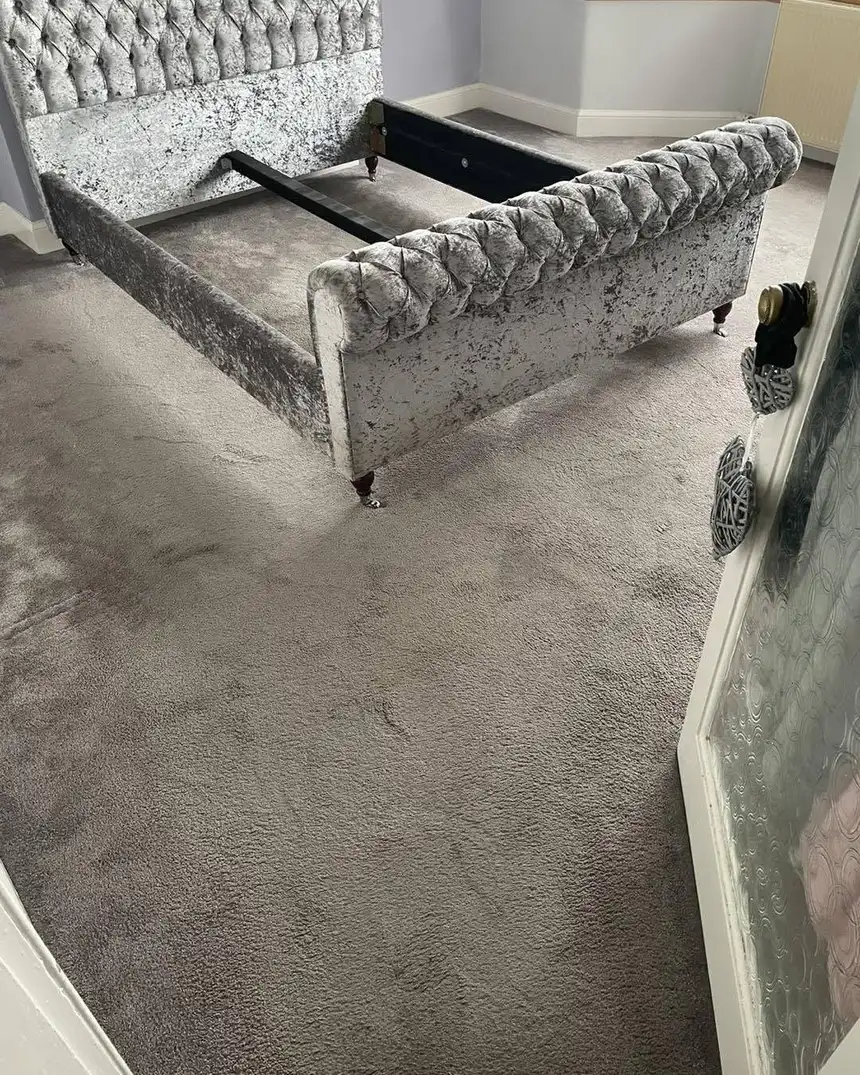 Grey bedroom carpet around a velvet bed frame looking flat, patchy and dull