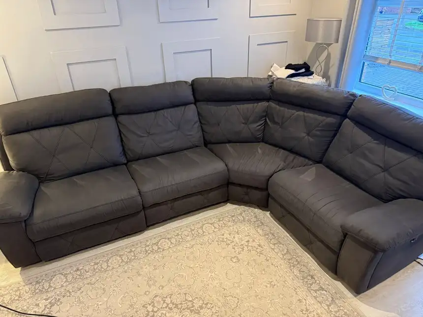 Large taupe fabric corner recliner sofa looking dark and flattened before cleaning