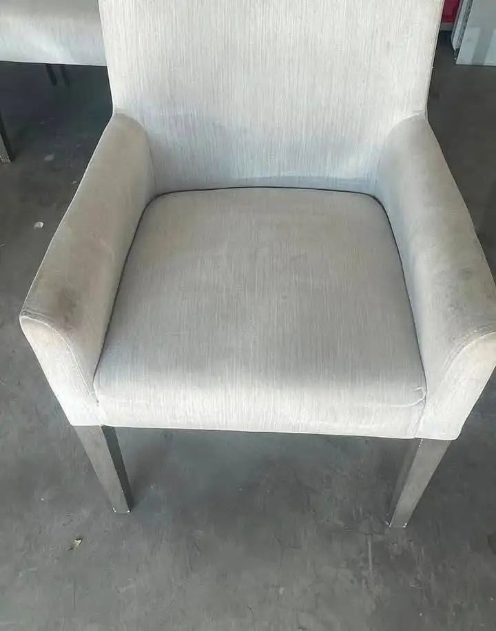Pale grey dining armchair with darker soiling along the arms and seat