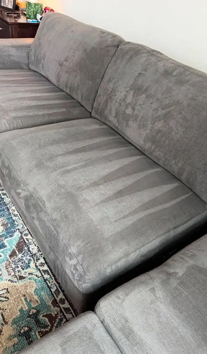 Grey fabric sofa after hot water extraction, ring stain gone and damp strokes visible